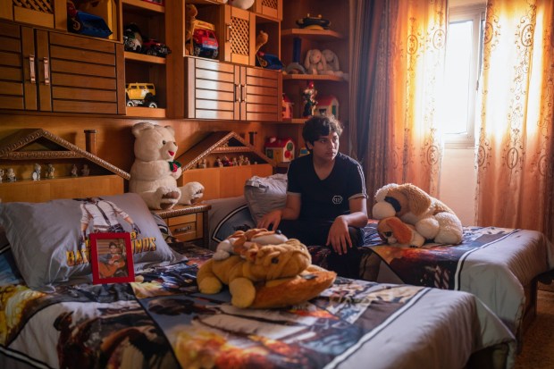 Ahmed Hamadneh, 15, sits on his bed in the bedroom he shared with his twin brother Mahmoud, in Jenin, West Bank, Wednesday, June 5, 2024. Witnesses said Mahmoud was killed by an Israeli sniper on his way home from school. (AP Photo/Bram Janssen)