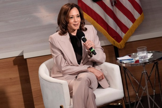Vice President Kamala Harris sits in an armchair holding a microphone