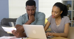 A couple looks at a laptop