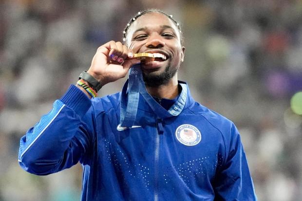 FILE - Gold medalist, Noah Lyles, of the United States, poses on the podium after the men's 100-meter final at the 2024 Summer Olympics, Monday, Aug. 5, 2024, in Saint-Denis, France. (AP Photo/Matthias Schrader, File)