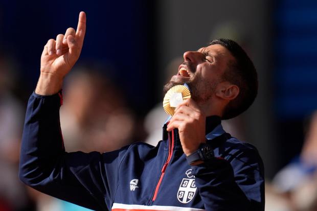 FILE - Serbia's Novak Djokovic shows his gold medal after defeating Spain's Carlos Alcaraz in the men's singles tennis final at the Roland Garros stadium during the 2024 Summer Olympics, Sunday, Aug. 4, 2024, in Paris, France. (AP Photo/Manu Fernandez, File)
