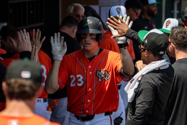 Norfolk Tides infielder Coby Mayo (23) is congratulated by teammates after hitting a solo home run in the third inning of a game against the Gwinnett Stripers at Harbor Park on Sunday, April, 28, 2024, in Norfolk, Va. (Mike Caudill for The Virginian-Pilot)