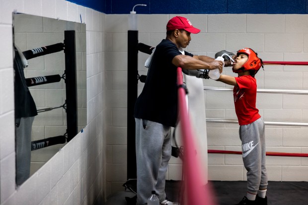 Jachai Blake takes a break to get water from assistant coach Dorin Spivey during practice at the Park Place Community Center on Thursday, Sept. 12, 2024. (Kendall Warner / The Virginian-Pilot)
